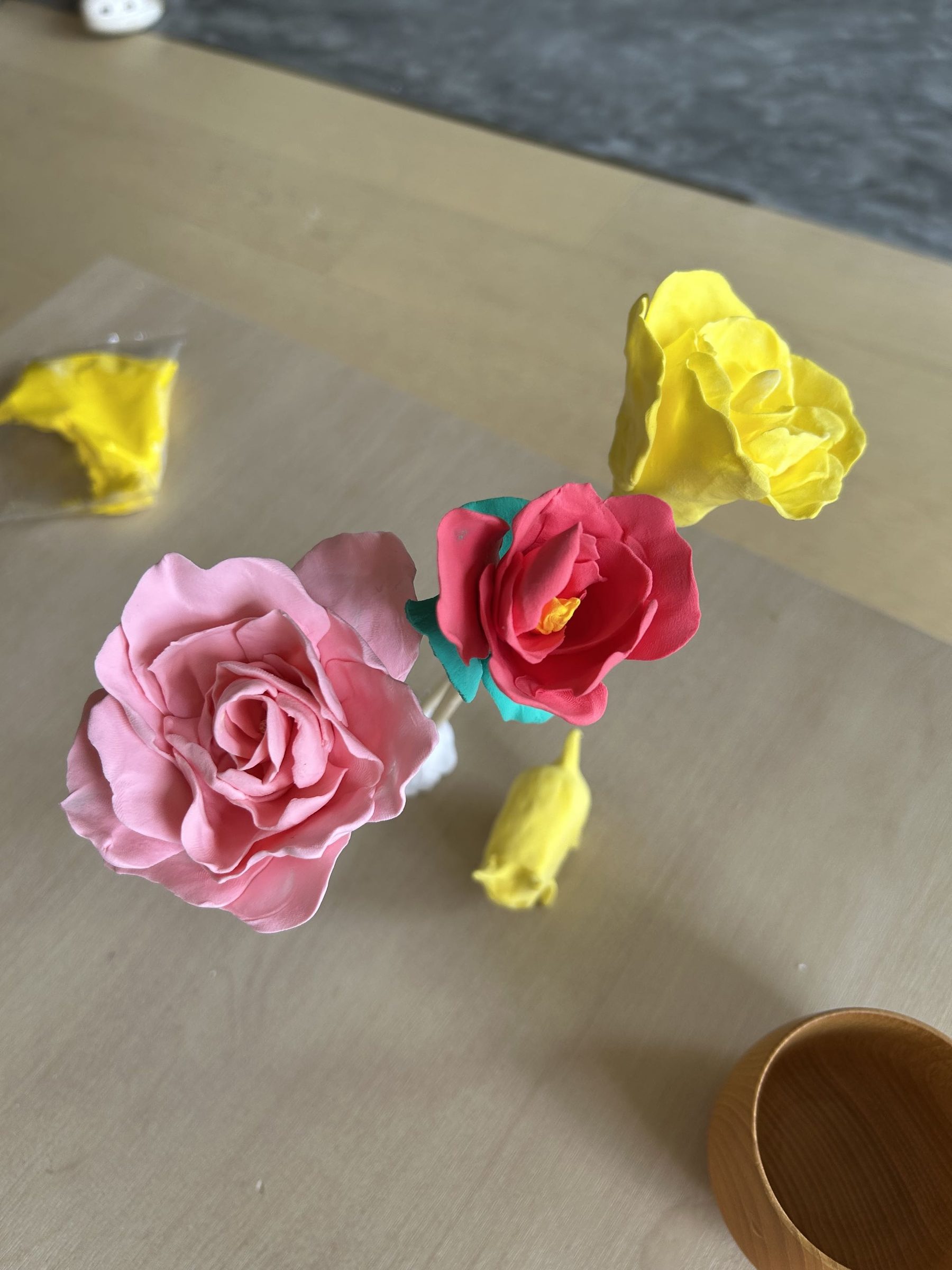粘土艺术疗愈工作坊活动照片：粉色、黄色与红色粘土花作品